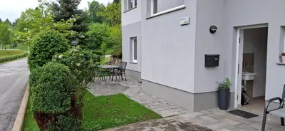 a white building with a courtyard with a table and chairs at Alpes in Radovljica