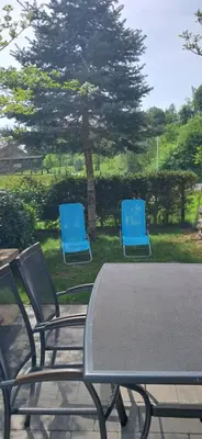 two blue chairs and a table in a yard at Alpes in Radovljica