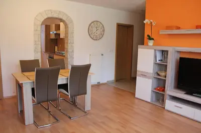 a dining room with a table and chairs and a television at Alpes in Radovljica