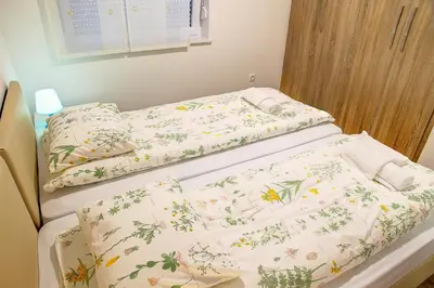 two beds in a hospital room with flowers on them at Apartment Vita near Terme Paradiso in Dobova