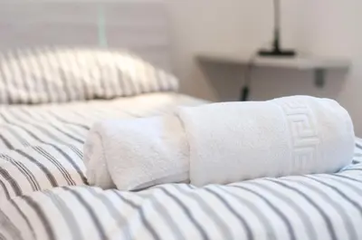two white towels sitting on top of a bed at Apartment Vita near Terme Paradiso in Dobova