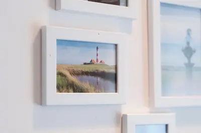 a picture frame on a wall with a picture of a lighthouse at Apartment Vita near Terme Paradiso in Dobova