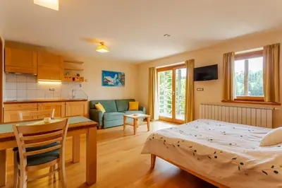 a living room with a kitchen and a dining room at Posestvo Laz - The Laz Estate in Voglarji