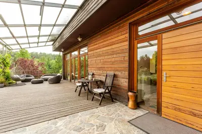 a patio with a table and chairs and a glass door at Posestvo Laz - The Laz Estate in Voglarji