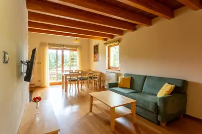 a living room with a green couch and a table at Posestvo Laz - The Laz Estate in Voglarji