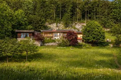 a house in the middle of a field with trees at Posestvo Laz - The Laz Estate in Voglarji