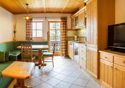 a kitchen with a table and a dining room at Alpska perla Apartments in Cerkno