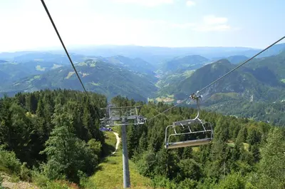 a gondola ride up a mountain in the mountains at Alpska perla Apartments in Cerkno
