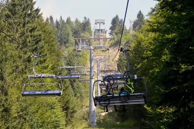 a gondola ride up a mountain with people on it at Alpska perla Apartments in Cerkno