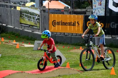 two young boys riding bikes in an obstacle course at Alpska perla Apartments in Cerkno