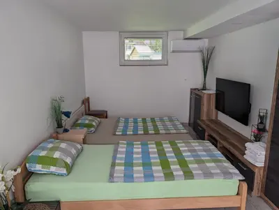 a bedroom with two beds and a flat screen tv at Apartment Mojca near Bled in Zabreznica