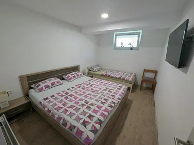 a bedroom with two beds and a flat screen tv at Apartment Mojca near Bled in Zabreznica