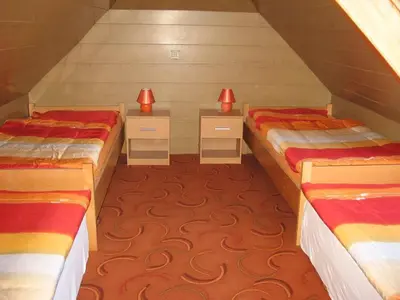 two beds in a attic room with red lights on them at Apartments and rooms Oasis of peace in Bovec