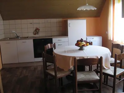 a kitchen with a table with a bowl of fruit on it at Apartments and rooms Oasis of peace in Bovec