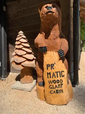 a statue of a brown bear holding a sign at Wooden Cabin Kamna Gorica in Kamna Gorica