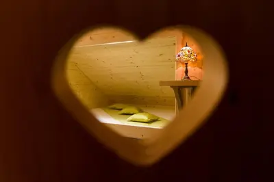 a heart shaped room with a bed and a lamp at Penzion Berc in Bled