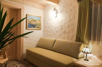 a living room with a couch and a lamp at Penzion Berc in Bled