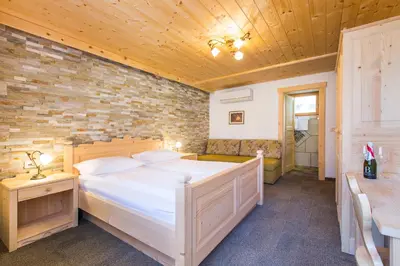 a bedroom with a bed and a brick wall at Penzion Berc in Bled