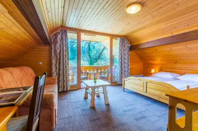 a bedroom with a bed and a table in a room at Penzion Berc in Bled