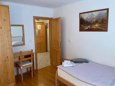 a bedroom with a bed and a desk and a mirror at TURISTIČNA KMETIJA STREVC in Solčava