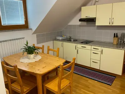 a kitchen with a wooden table with a plant on it at TURISTIČNA KMETIJA STREVC in Solčava