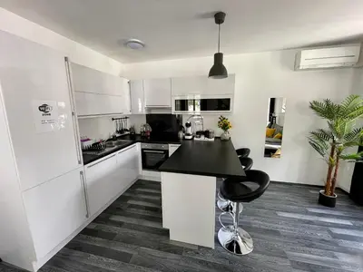 a kitchen with white cabinets and a black counter top at Apartment Tina in Bovec