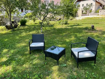 two chairs and a table in the grass at Apartment Tina in Bovec
