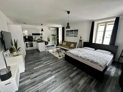 a bedroom with a bed and a living room at Apartment Tina in Bovec