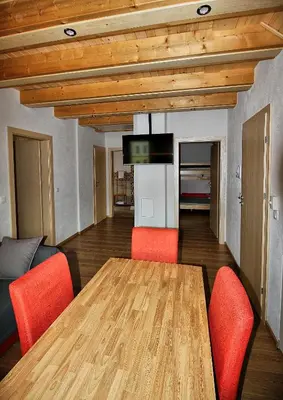 a dining room with a wooden table and orange chairs at Apartments Pikon in Bohinj