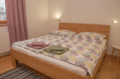 a bedroom with a bed with a wooden headboard at Apartments Pikon in Bohinj