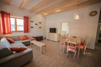 a living room with a couch and a table at Apartments Pikon in Bohinj