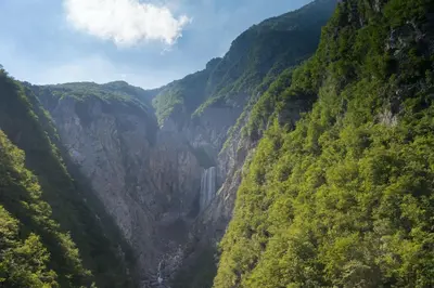 a mountain canyon with a waterfall in the middle at Apartment Vida in Bovec