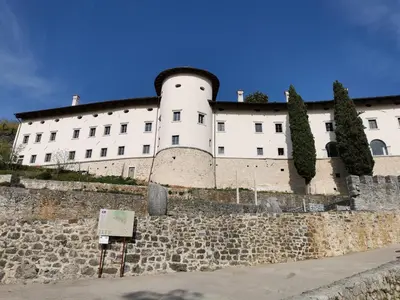 a large white building on top of a stone wall at Apartma Furlan in Štanjel