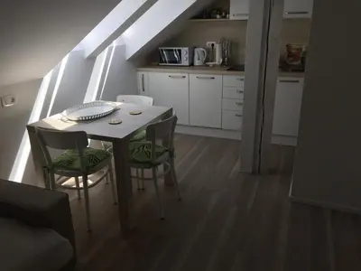 a kitchen with a table and chairs in a room at Kirhouse Apartment in Bohinjska Bela