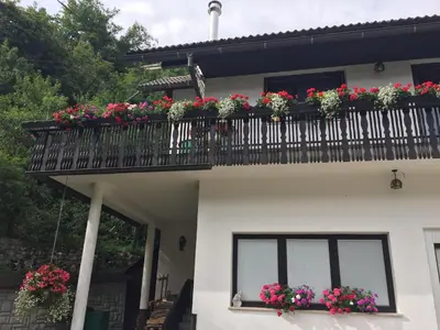 a house with a balcony with flowers on it at Kirhouse Apartment in Bohinjska Bela