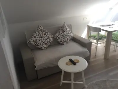 a living room with a couch and a table at Kirhouse Apartment in Bohinjska Bela