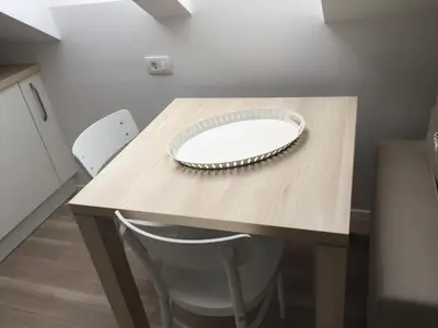 a table with two chairs and a plate on it at Kirhouse Apartment in Bohinjska Bela