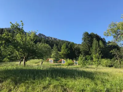 a view of a field with trees and tents at Mountain view Glamping in Dovje
