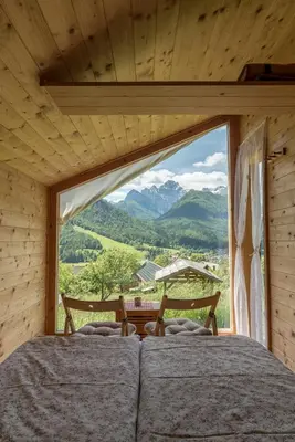 a bedroom with a large window with a view of mountains at Mountain view Glamping in Dovje