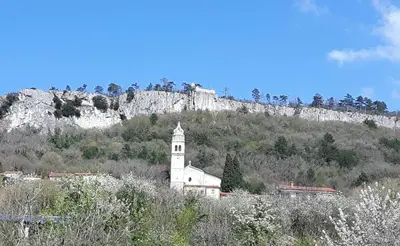 a white church sitting on top of a mountain at Apartment Beautiful Črni Kal in Črni Kal