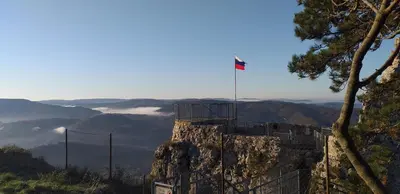 a flag on the top of a mountain with clouds at Apartment Beautiful Črni Kal in Črni Kal