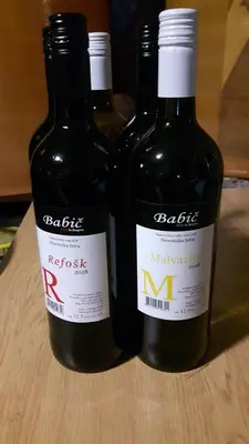 three bottles of wine sitting on a wooden table at Apartment Beautiful Črni Kal in Črni Kal