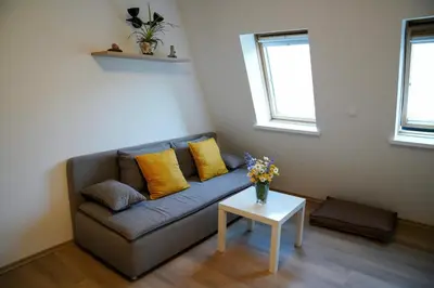 a living room with a couch with yellow pillows and a table at Apartment Alpea in Bovec