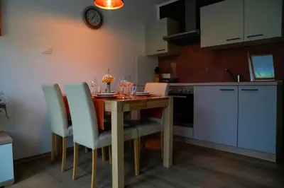 a kitchen with a wooden table and chairs in a kitchen at Apartment Alpea in Bovec