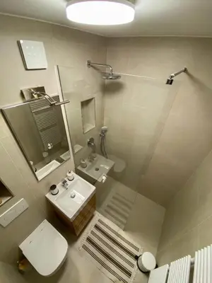 a bathroom with a sink and a toilet and a mirror at Apartment Alpea in Bovec