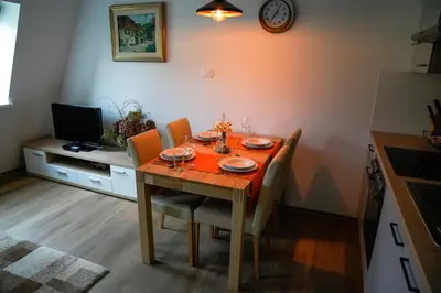 a dining room with a table with chairs and a television at Apartment Alpea in Bovec
