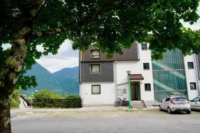 a building with a car parked in front of it at Apartment Alpea in Bovec
