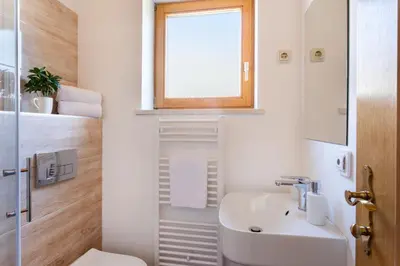 a bathroom with a sink and a toilet and a window at Holiday Lake in Bled
