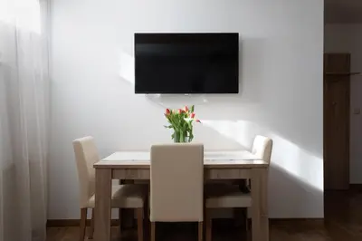 a dining room table with a vase of flowers on it at Holiday Lake in Bled