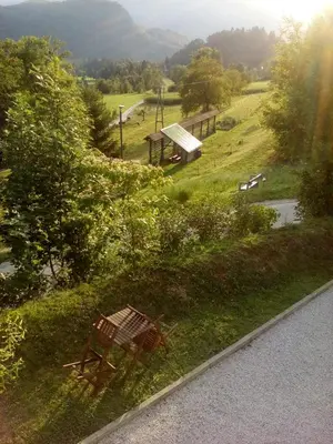 a bench sitting in the grass next to a park at Apartment Visak in Bled